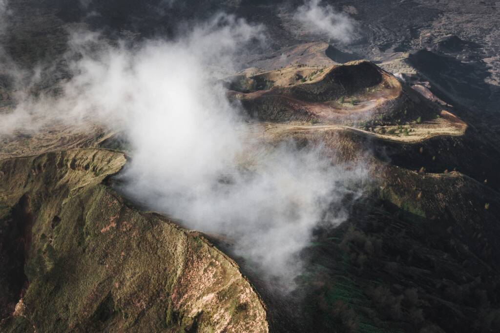 Aerial view of Batur volcano caldera in Bali. Volcanic black texture and crater rim